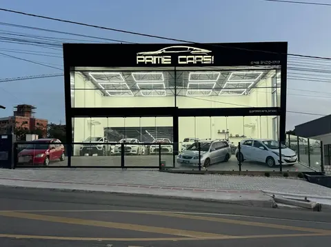Fachada da Prime Cars Brasil, com o showroom iluminado por hexágonos de LED